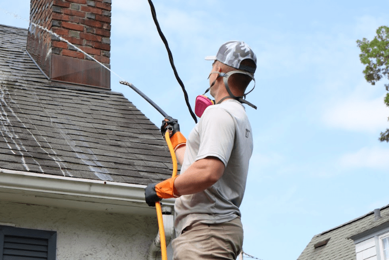 Julius cleaning a roof by PreshClean Inc.
